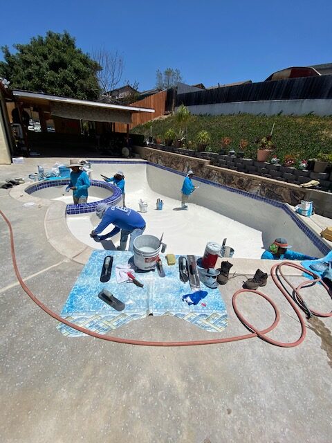 pool crew at work resurfacing a pool in san diego